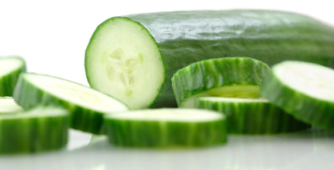 Cucumber and slices on a white background.